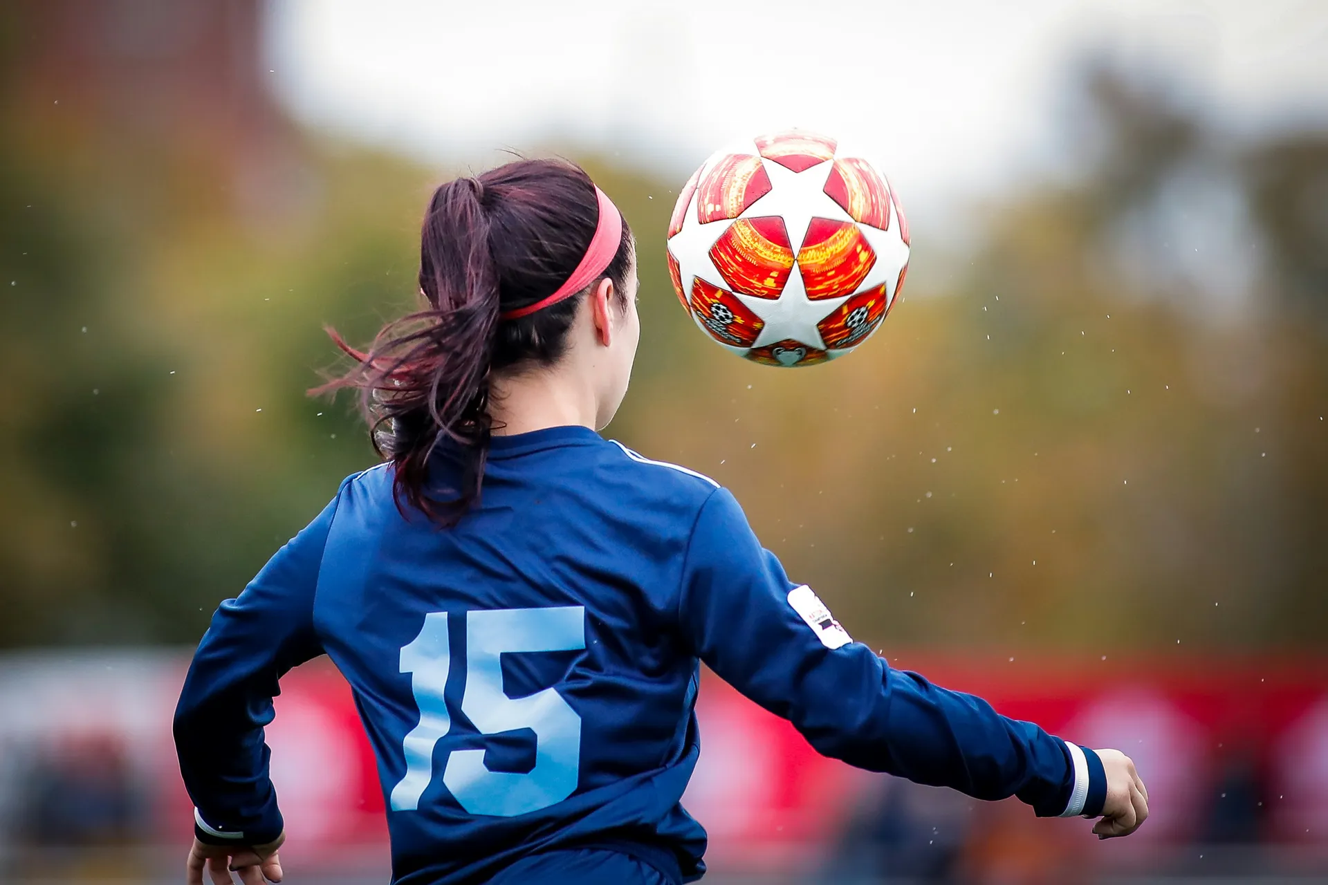 A player in a number 15 jersey chesting the ball down during a fall league match